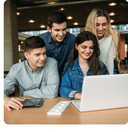 Students smiling together around a laptop upon attaining recognised competencies
