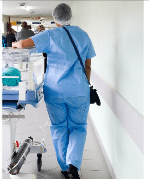 Healthcare professional nurse walking down medical hallway representing Australian overseas health insurance
