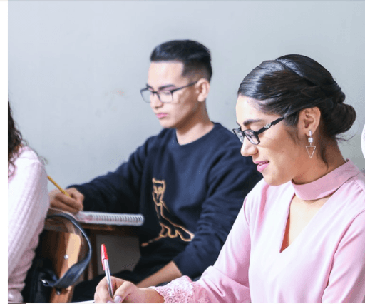 Students focused on writing in classroom for NAATI, IELTS, and PTE preparation